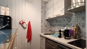 A kitchen with a microwave, kettle, and utensils on the counter. - 1 RR6171 - (Megève)