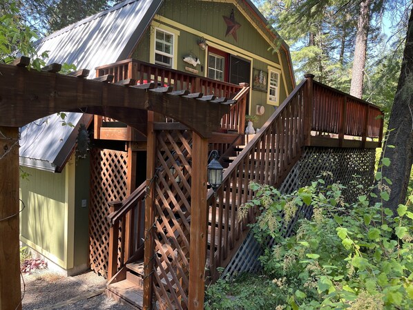 A wooden cabin with a porch, a staircase, and a small deck.