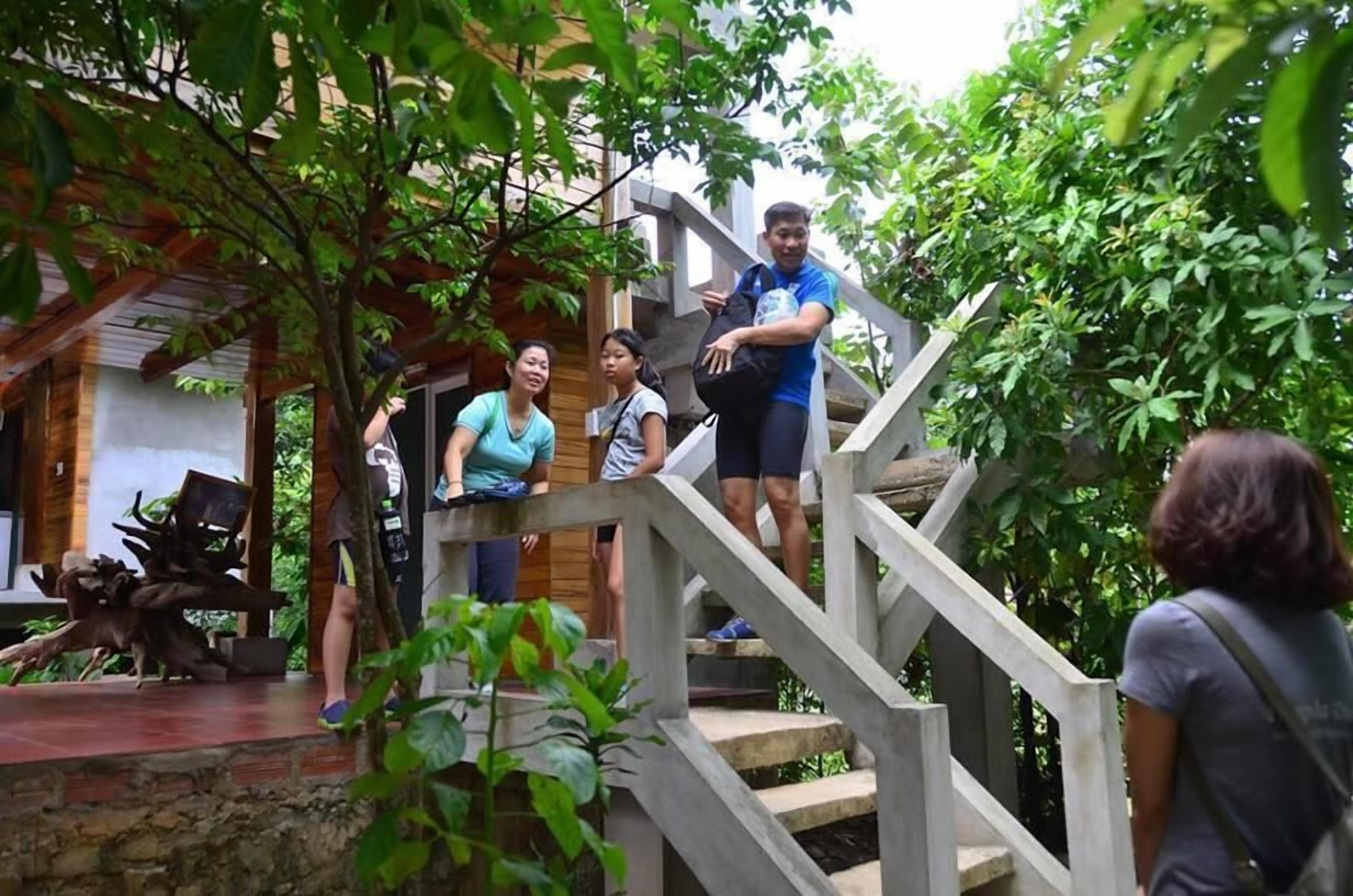 A staircase leading to a wooden deck with a rustic stone wall and a sculpture.