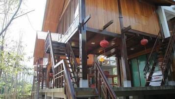A wooden building with multiple levels, including a staircase leading to the upper floor.