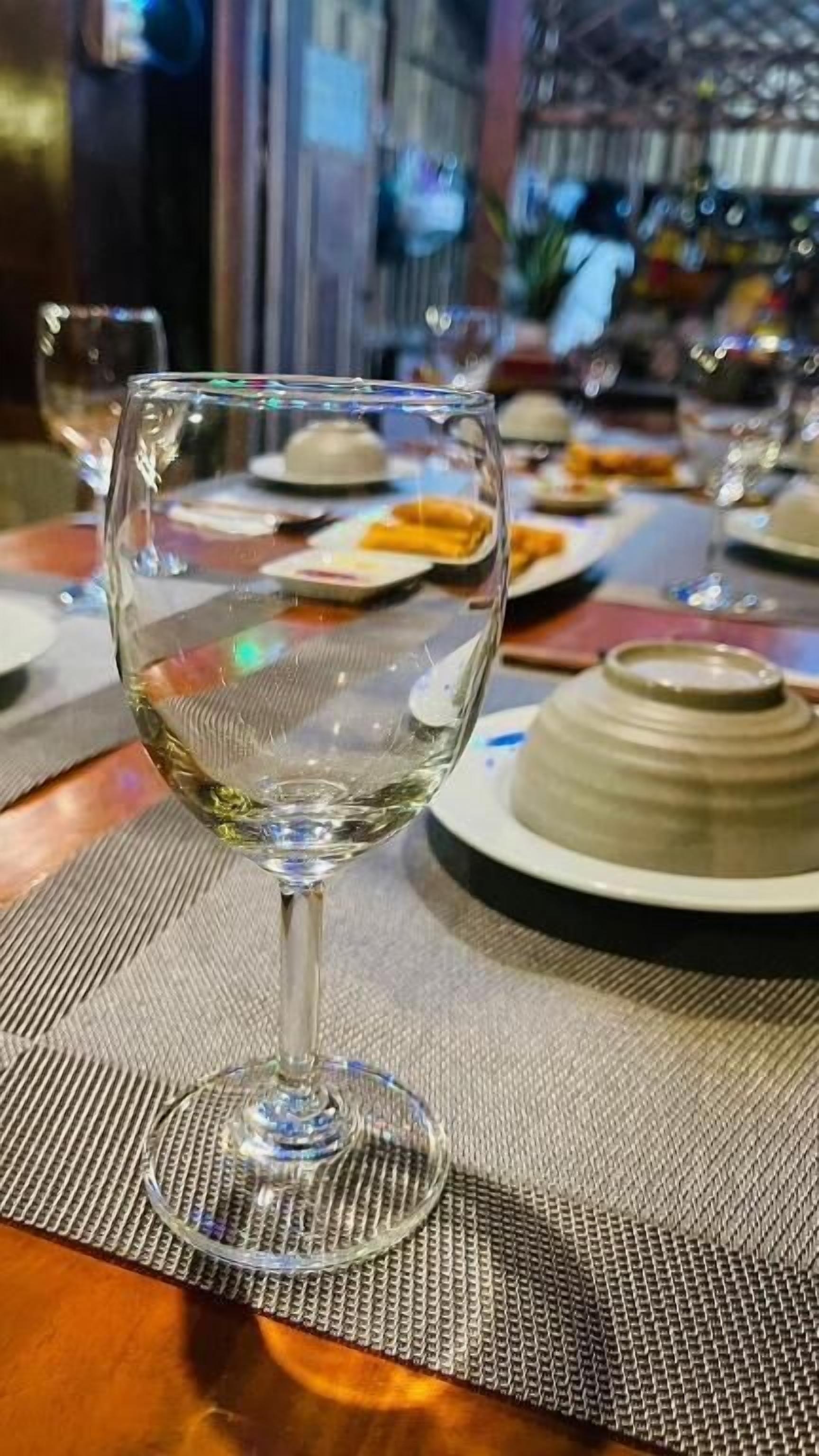 Une table avec un verre à vin, des assiettes et un dessert.