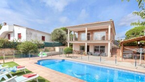A two-story house with a swimming pool, a covered patio, and a small garden area. - Vacation home Dorian by Interhome (St Antoni de Calonge)