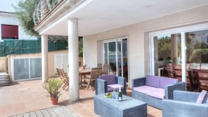 An outdoor patio with wicker furniture, a dining table, and a potted plant. - Vacation home Dorian by Interhome (St Antoni de Calonge)
