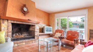 A living room with a fireplace, a television, and comfortable seating. - Vacation home Dorian by Interhome (St Antoni de Calonge)