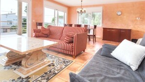 A spacious living room with a sofa, a dining table, and a kitchen area. - Vacation home Dorian by Interhome (St Antoni de Calonge)