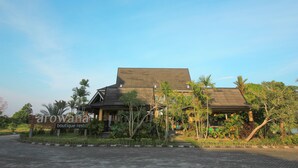 A two-story building with a dark roof and a sign reading "arowana boutique rest." - OYO 1153 Tiga Dara Hotel & Resort Syariah (Pekanbaru)