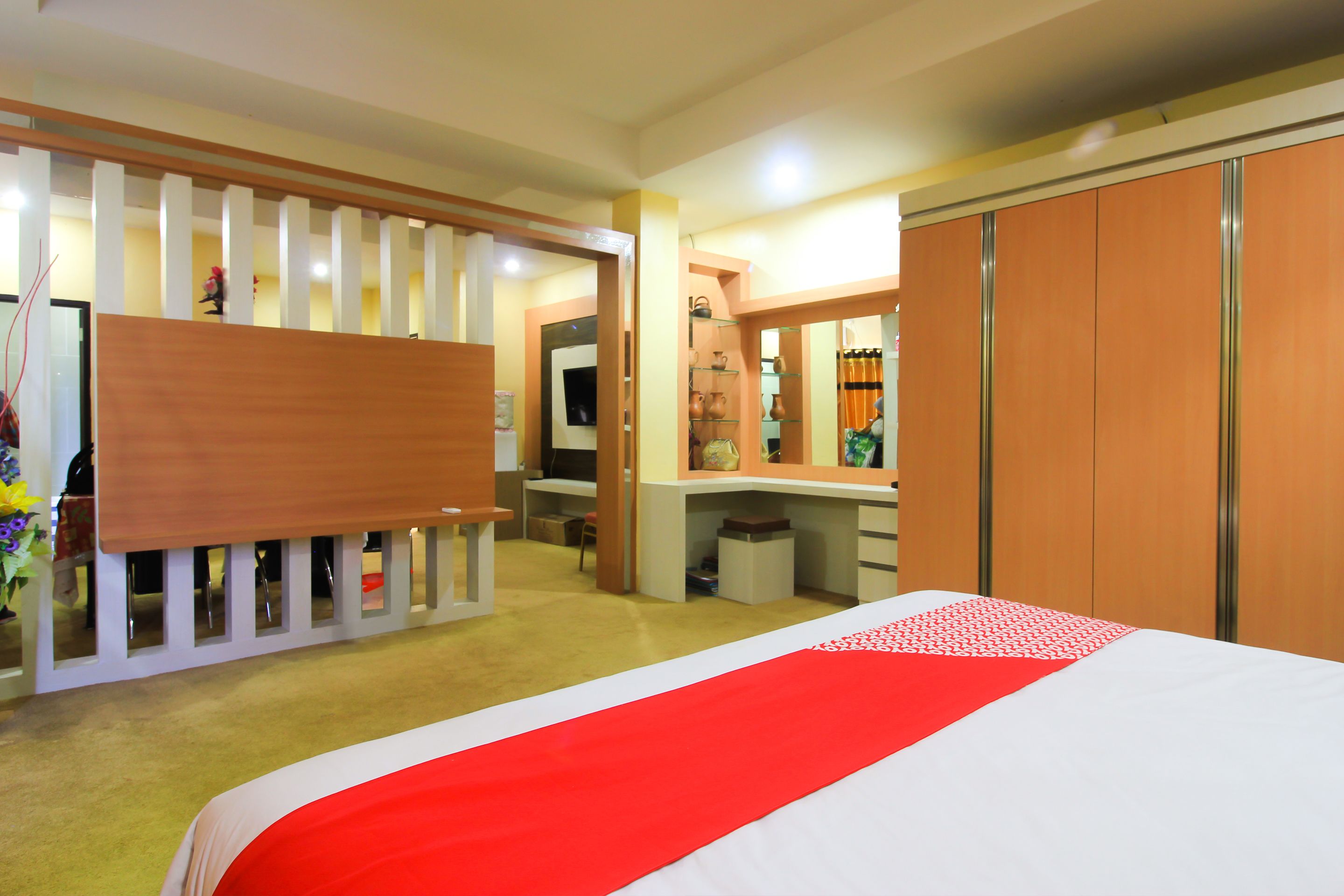 Una habitación de hotel con cama, escritorio, armario y espejo.