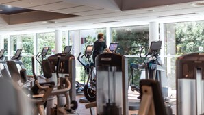 A gym with cardio machines and a person using an elliptical. - Mercure Geneva Airport  (Meyrin)