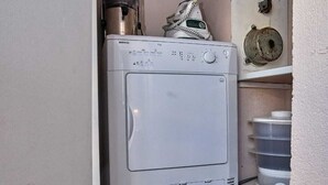 Un espace buanderie compact comprenant un lave-linge à chargement frontal et un sèche-linge superposé.
