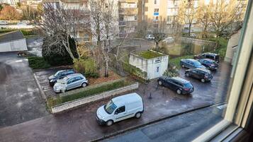 A parking area with several cars and a small building with a green roof.