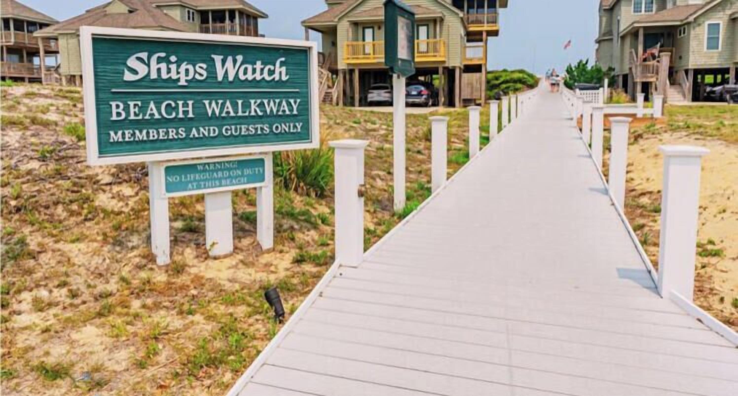 A beach walkway sign for Ships Watch with a warning about no lifeguard on duty.