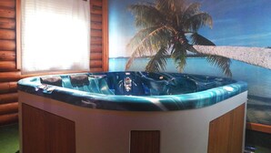 Una habitación con decoración interior estilo cabaña de madera, un jacuzzi y un mural de una playa.