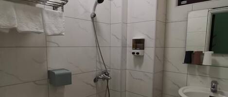 Um banheiro pequeno com vaso sanitário, chuveiro e pia.