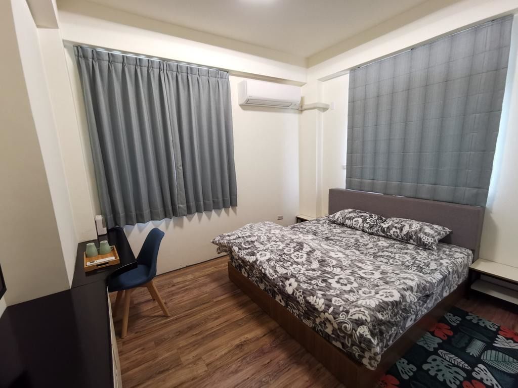 Une chambre à coucher avec un lit, un bureau, une chaise et une fenêtre avec des rideaux.