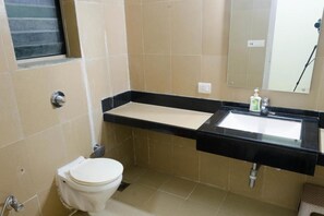 A bathroom with a toilet, sink, and mirror.