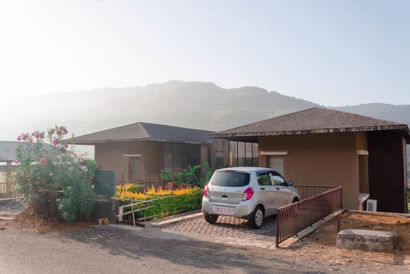 A residential building with a car parked in front.