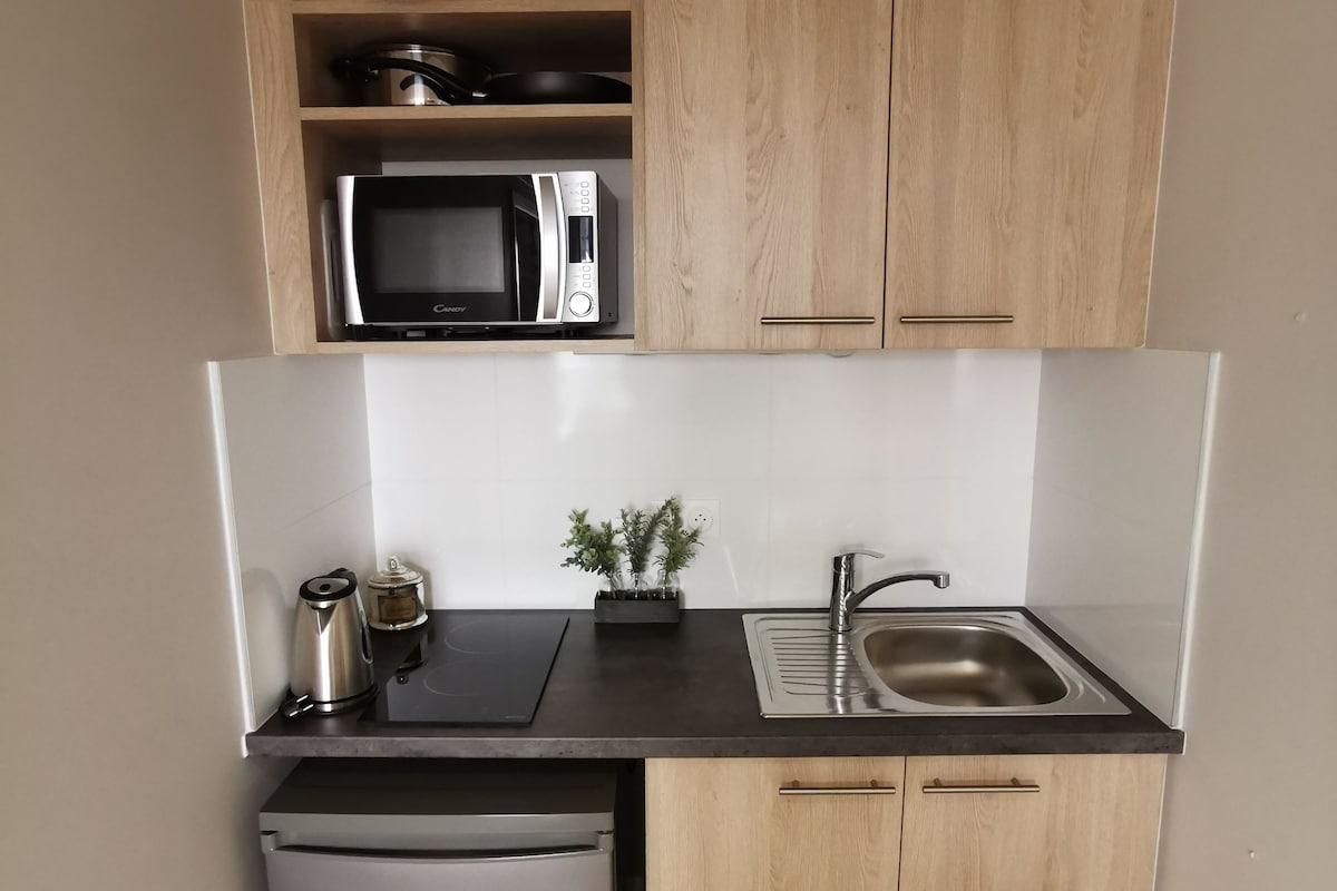 A compact kitchen with a microwave, sink, and dishwasher.