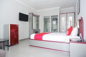 A modern hotel room with a bed, a TV, a wardrobe, and a desk. - OYO 1284 Executive Residence (Semarang)