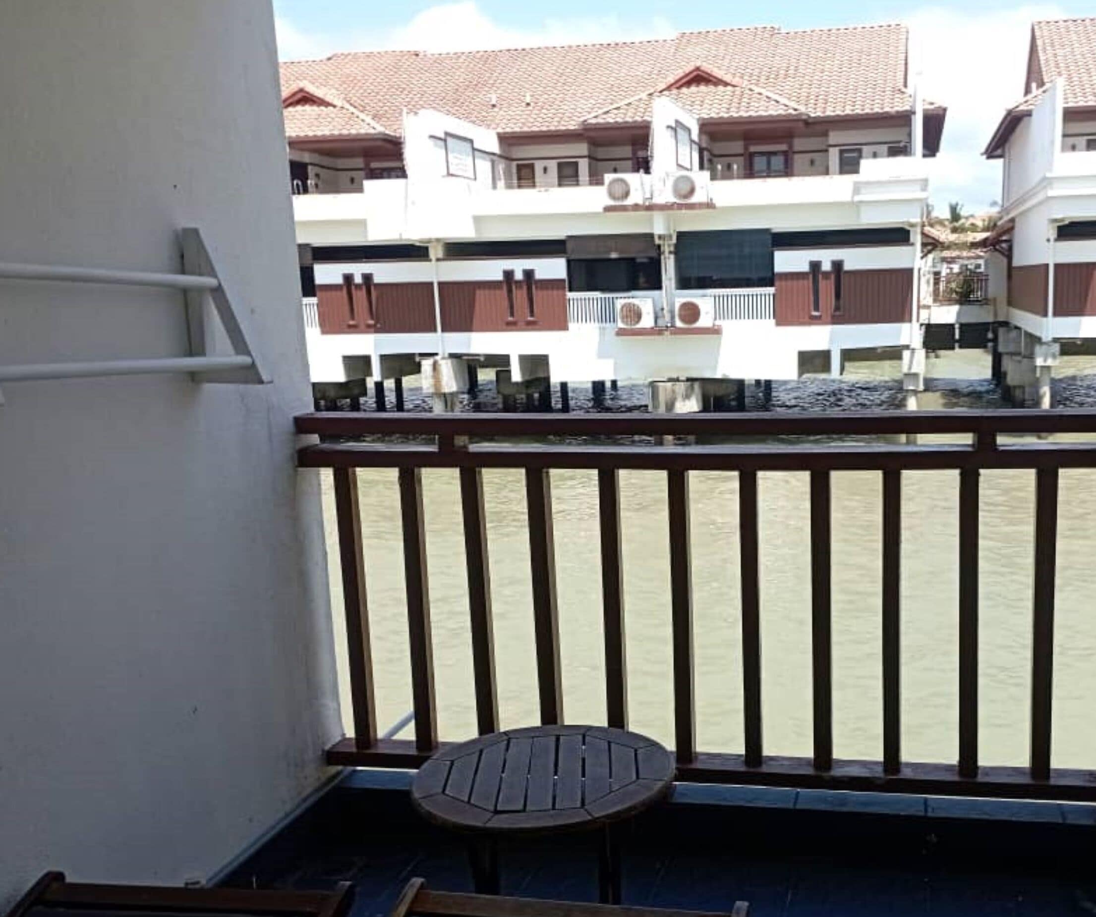 A balcony with a view of a river and buildings in the background.