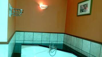 A bathroom with a bathtub, a towel rack, and a framed picture on the wall.