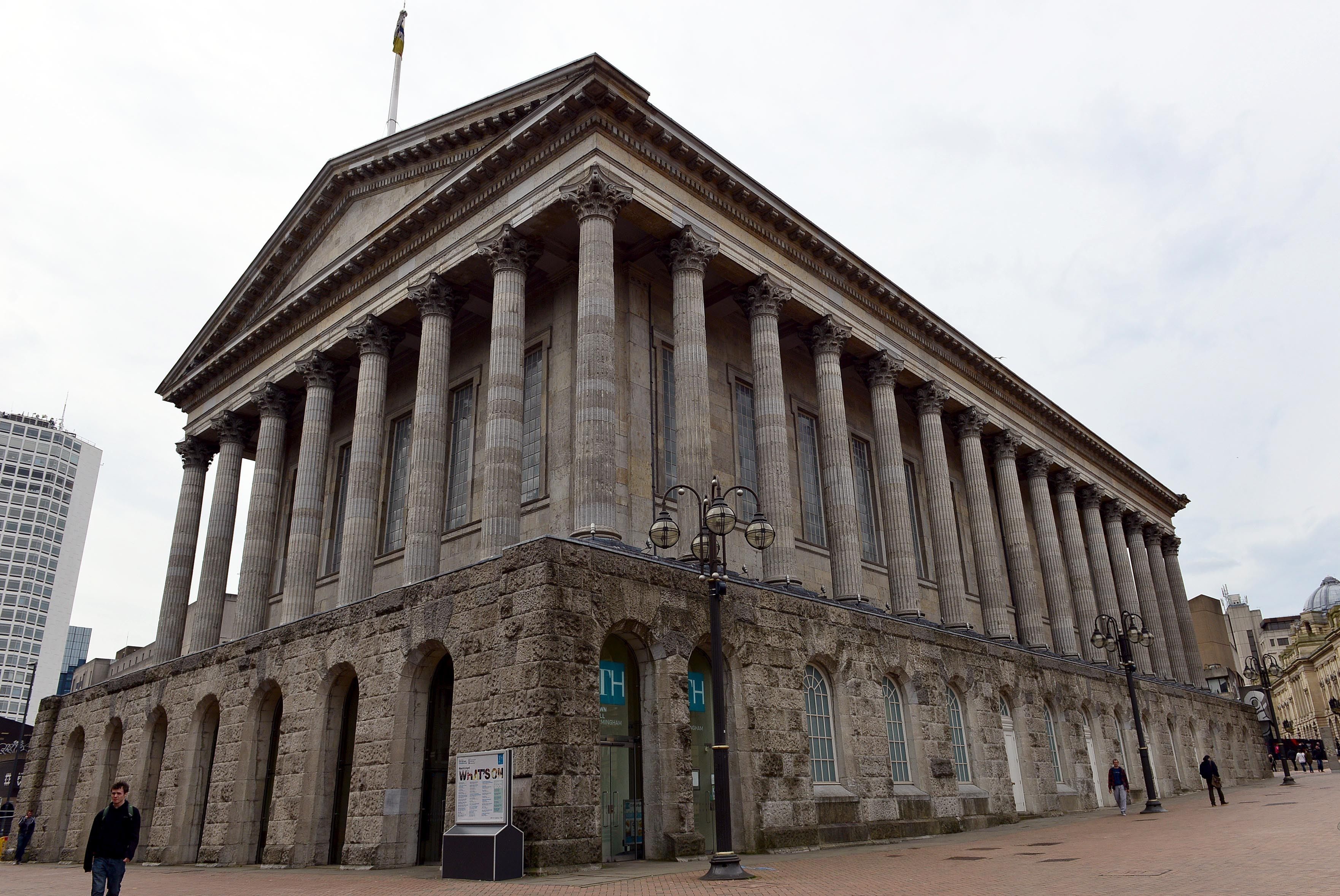 A large stone building with a classical architectural style, featuring tall columns and arched windows.