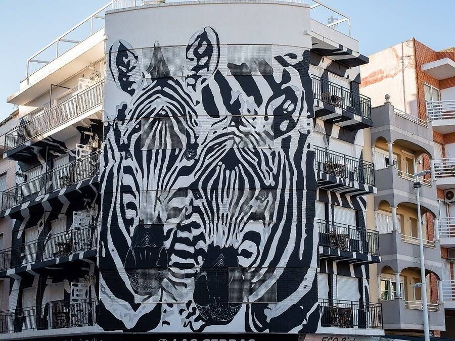 Fachada de edificio con un gran mural de cebra.