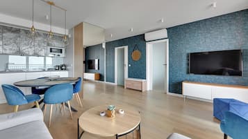 Un espacio habitable moderno con cocina, comedor y zona de entretenimiento.