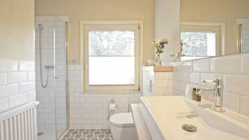 A bathroom with a shower, toilet, and sink.