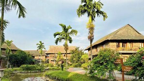 A resort with thatched-roof buildings, a swimming pool, and a bike area. - Can Tho Ecolodge (Can Tho)