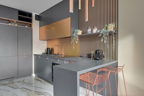A modern kitchen with a central island, grey cabinetry, and a stainless steel sink.