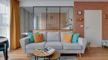 A modern living room with a grey sofa, wooden coffee table, and patterned rug.