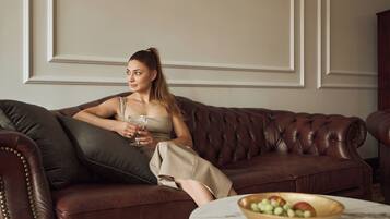 A person seated on a brown leather sofa with a marble table in front.
