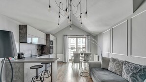 Een moderne keuken met een centraal eiland, barkrukken en hanglampen.