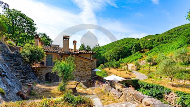 A stone house with a tiled roof, surrounded by a stone wall and a small garden. - Villa Gabriella Chianti Toscana (Città Metropolitana di Firenze)