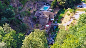 An aerial view of a villa with a swimming pool, stone architecture, and a surrounding natural landscape. - Villa Gabriella Chianti Toscana (Città Metropolitana di Firenze)