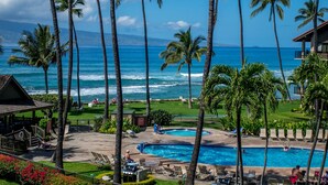 Un resort con piscina, poltrona relax e vista sull'oceano.