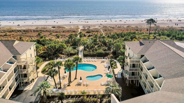 A resort with a pool area, beachfront view, and multiple buildings. - #121 BREAKERS, HILTON HEAD ISLAND, SC (Hilton Head Island)