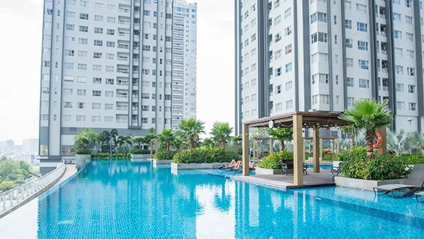 A swimming pool with a gazebo, surrounded by greenery and tall residential buildings. - Enjoy Saigon Sunrise City (Ho Chi Minh City)