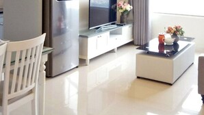 A modern living room with a sofa, a coffee table, and a television. - Enjoy Saigon Sunrise City (Ho Chi Minh City)