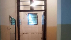 A small bathroom with a sink, a mirror, and a window. - One World Apartments Bamburi (Mombasa)