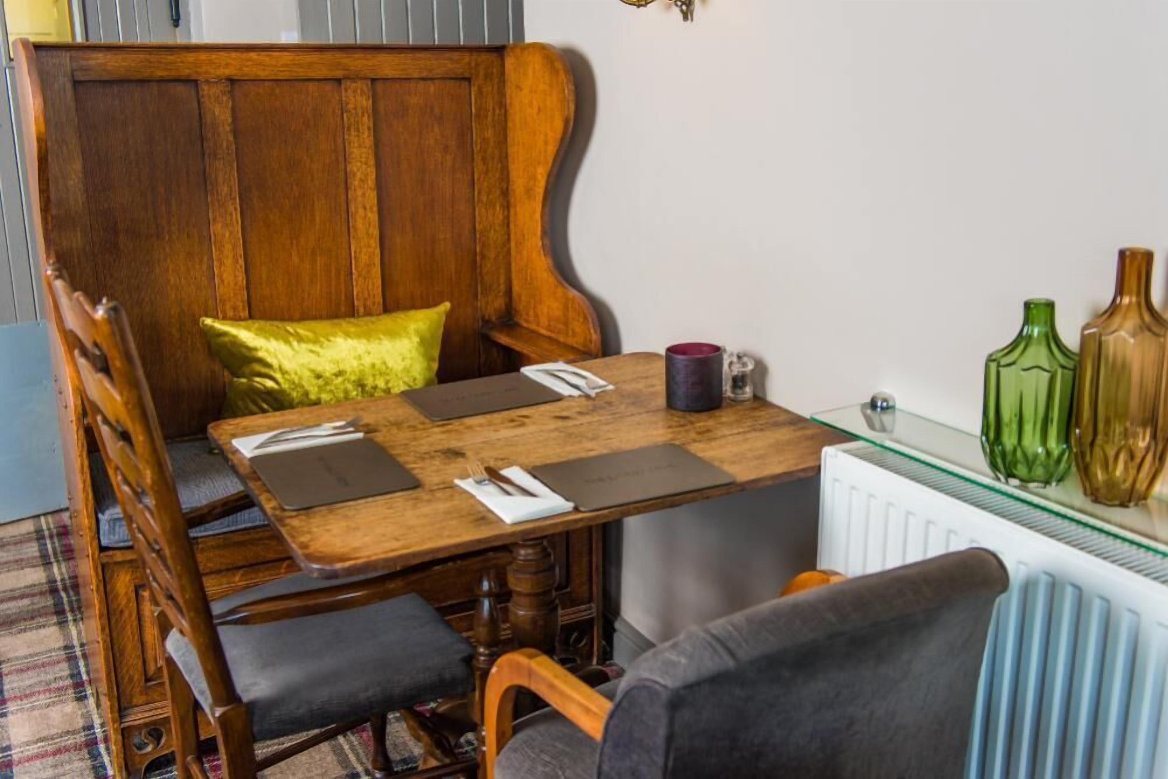 A dining area with a wooden table, chairs, and a bench.