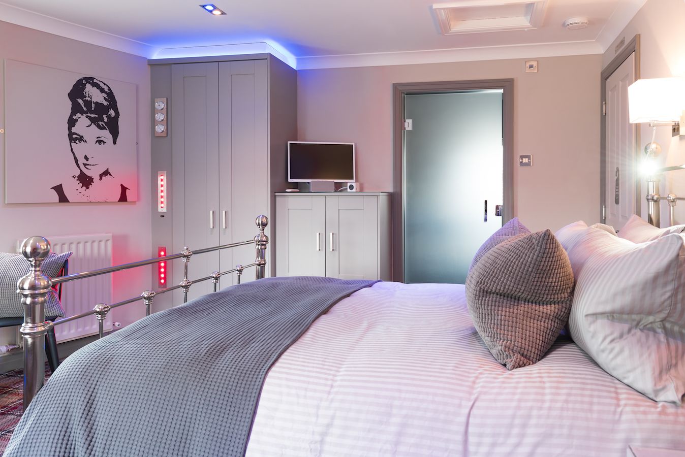Ein Schlafzimmer mit einem großen Bett, einem Fernseher und einem Kleiderschrank.