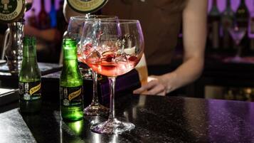 A bar setting with a drink in a glass, a bottle of Schweppes ginger ale, and a tap labeled 'Timothy Taylor's Knowles Spring'.