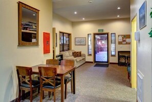 A hotel lobby with a wooden reception desk, a sofa, and a carpeted floor. - Giant Steps 17 - 2 bdrm 2 bath ski in/out in building one - Next to the slopes (Brian Head)
