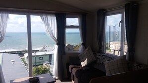 Ein Zimmer mit Meerblick, eine Couch mit Kissen und ein Tisch mit einer Schale.