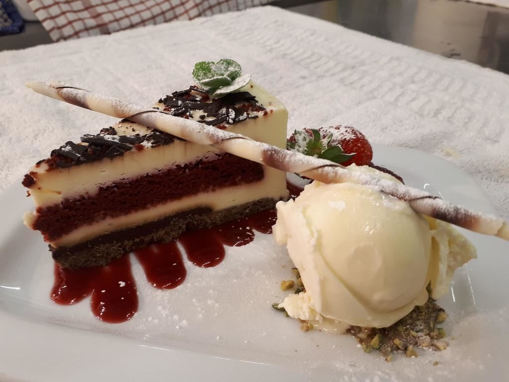 Un piattino con una torta a strati e una pallina di gelato.