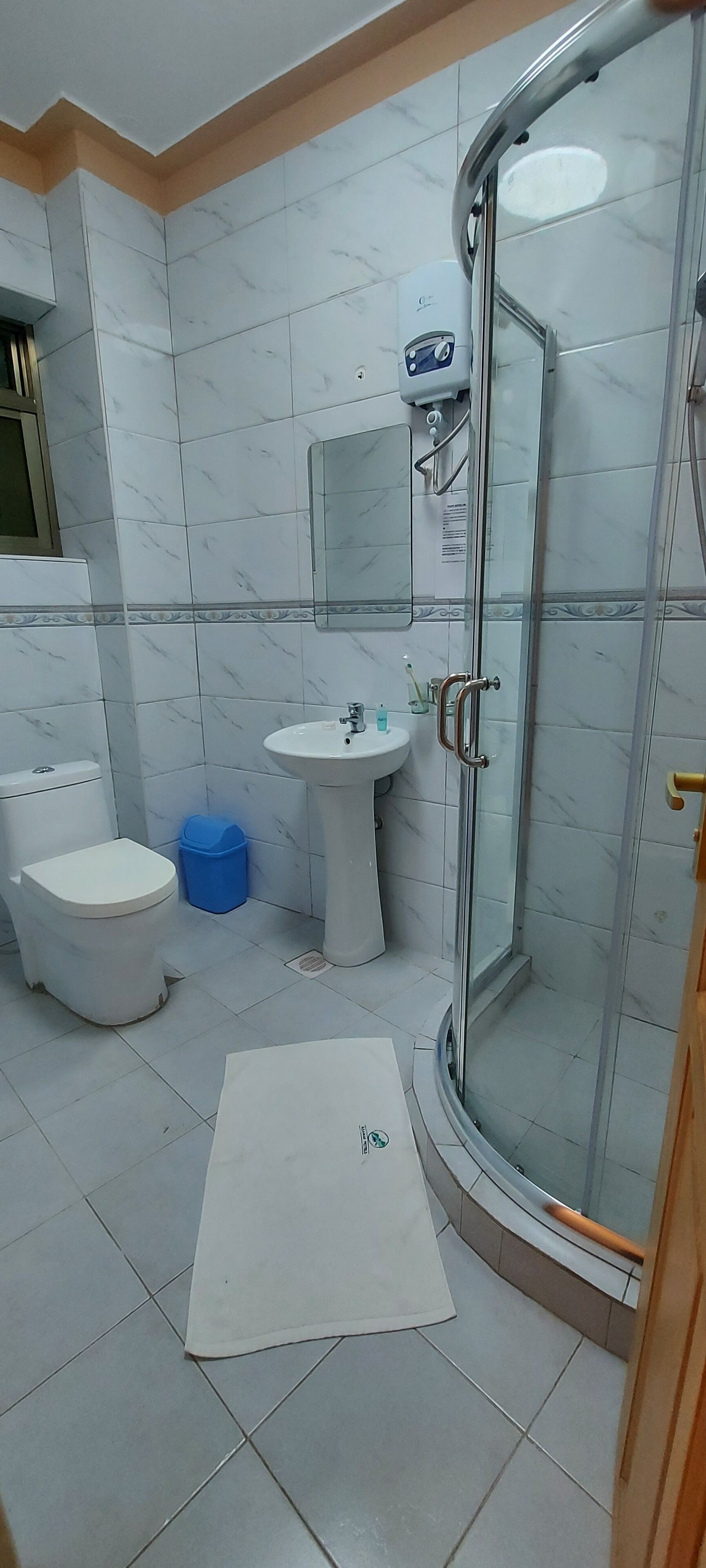 A bathroom with a toilet, sink, and shower.