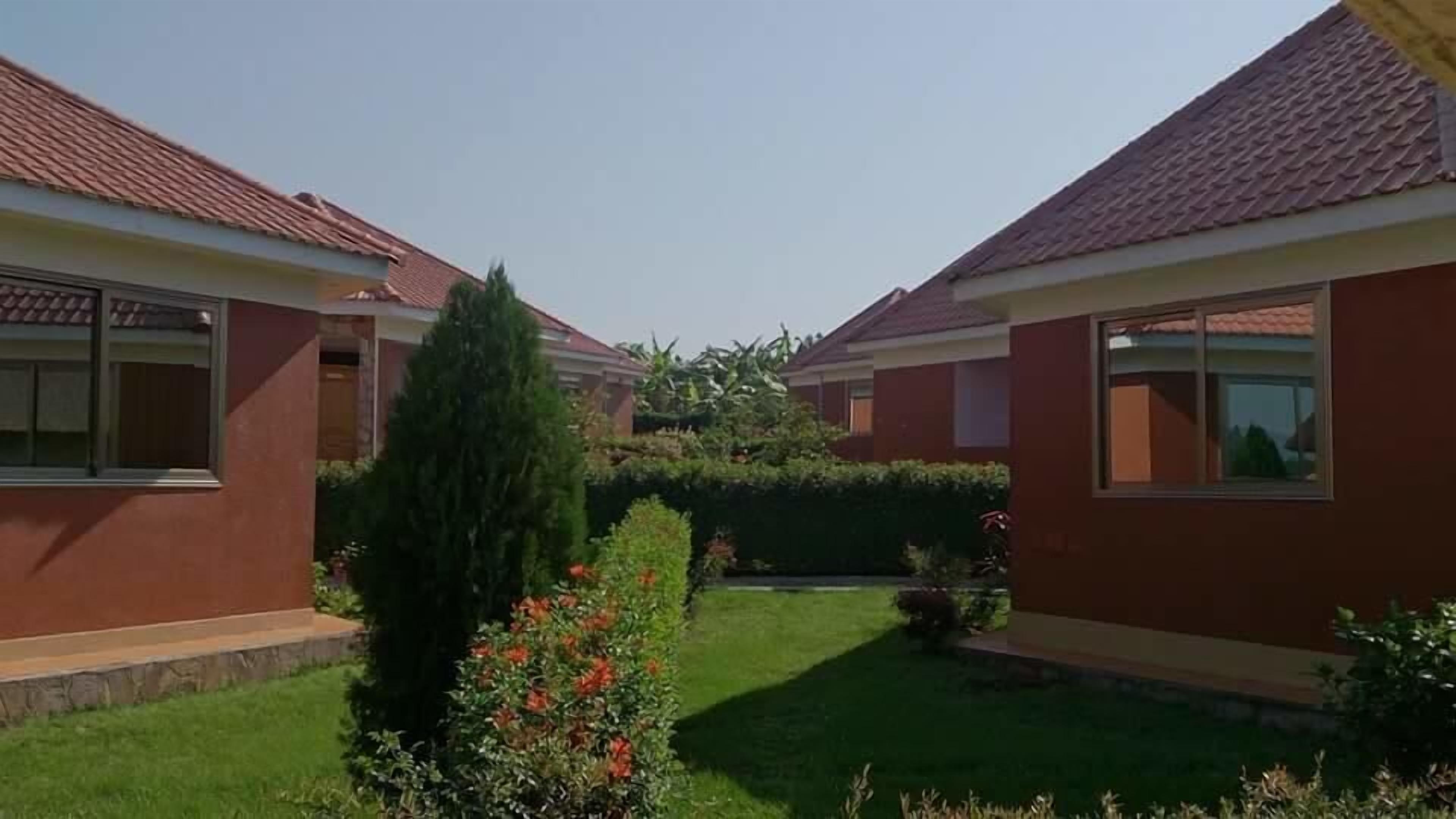 Una zona residenziale con due case, ciascuna con tetto in tegole e un piccolo giardino anteriore.
