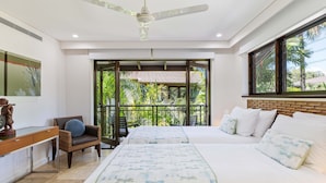 Quarto com duas camas, um ventilador de teto, uma escrivaninha e uma cadeira.