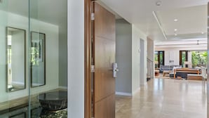 Um interior moderno com uma porta de madeira, uma parede de vidro e uma bacia de pedra.